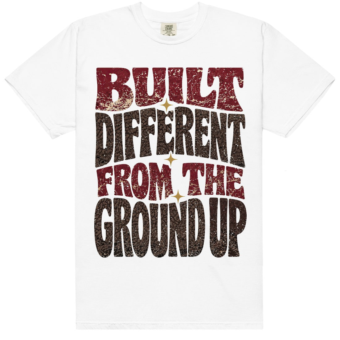 White HeatLit ‘Built Different From The Ground Up’ tee with a Bin 23 front graphic — cardinal-red type, chocolate-brown elephant print and gold star sparks on a cream speckle.